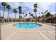 A turquoise community pool is surrounded by palm trees, lounge chairs, and cabanas for relaxing by the water at 421 Raindance Dr, Henderson, NV 89014