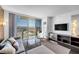 Bright living room featuring comfortable seating, large TV, and expansive window with city views at 4381 W Flamingo Rd # 1003, Las Vegas, NV 89103