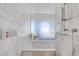Modern shower and bath area featuring marble tile walls at 4381 W Flamingo Rd # 1003, Las Vegas, NV 89103