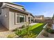 This home features an alluring outdoor space with a covered patio, lush green turf, and desert landscaping at 461 Cascade Heights Ave, Las Vegas, NV 89138