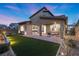 This home has a beautiful backyard with a covered patio, manicured landscaping, and green turf at 461 Cascade Heights Ave, Las Vegas, NV 89138