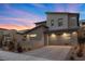 Modern home exterior with well-maintained landscaping, a gray garage door, and a brick driveway at 461 Cascade Heights Ave, Las Vegas, NV 89138