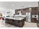 Modern kitchen with a large island, dark cabinets, stainless steel appliances, and an adjacent dining area at 461 Cascade Heights Ave, Las Vegas, NV 89138