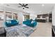 Spacious living room with tile floors, ceiling fan, large windows, and dark cabinets and island in kitchen at 461 Cascade Heights Ave, Las Vegas, NV 89138
