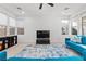Cozy living room with a TV, neutral colored tile floors, a bright sofa, and natural lighting at 461 Cascade Heights Ave, Las Vegas, NV 89138