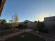 Landscaped backyard with trees, shrubs, and a small patch of grass at 4837 Skyraider St, North Las Vegas, NV 89031