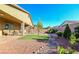 A backyard featuring decorative rock landscaping, a tree, and a covered patio at 4837 Skyraider St, North Las Vegas, NV 89031