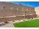 A backyard showcasing a retaining wall with thoughtful landscaping, synthetic grass, and neutral gravel at 50 Barrio Alto Ct, Henderson, NV 89011