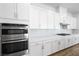 Modern kitchen featuring white cabinets, stainless steel appliances, and beautiful backsplash at 50 Barrio Alto Ct, Henderson, NV 89011
