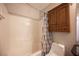 Bright bathroom with tiled shower-tub combo with a cabinet and neutral colored shower curtain at 5000 Charlo Dr, Las Vegas, NV 89131