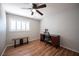 Bedroom featuring wood flooring, ceiling fan, plantation shutters, and a wooden desk at 5000 Charlo Dr, Las Vegas, NV 89131