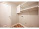 Laundry room featuring tile floor and shelving with washer and dryer hookups and a white painted door at 5000 Charlo Dr, Las Vegas, NV 89131
