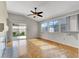 Bright living room featuring hardwood floors, ceiling fan, and sliding door to the backyard at 5244 Velazco Ln, Las Vegas, NV 89130