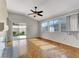 Bright living room featuring hardwood floors, ceiling fan, and sliding door to the backyard at 5244 Velazco Ln, Las Vegas, NV 89130