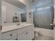 Bright bathroom with vanity and cabinets, a large mirror, and a tub with shower at 5256 Sherwood Forest Ln, Las Vegas, NV 89122