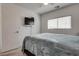 Cozy bedroom features soft carpeting, a mounted television, and a comfy gray bedspread at 5256 Sherwood Forest Ln, Las Vegas, NV 89122