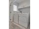 Bright laundry room with a full-sized washer and dryer, plus shelving above at 5256 Sherwood Forest Ln, Las Vegas, NV 89122