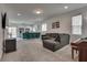 Open concept living room with grey sofa, piano, adjacent kitchen, and natural light at 5256 Sherwood Forest Ln, Las Vegas, NV 89122