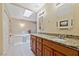 Bright bathroom featuring a large soaking tub, dual sinks with granite counters, and ample storage at 5518 Avenida Vaquero, Las Vegas, NV 89108