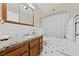 Bathroom features a granite vanity top, a large framed mirror, and white tiled floors and shower at 5518 Avenida Vaquero, Las Vegas, NV 89108