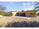 Tan single-story home with a wide driveway and attached two-car garage, surrounded by desert landscape at 5518 Avenida Vaquero, Las Vegas, NV 89108
