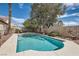 Enjoy the backyard oasis with sparkling pool, patio area, and mature trees at 6048 Pele St, North Las Vegas, NV 89031