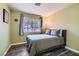 Cozy bedroom boasts wood-look floors and a large window with leafy view at 6048 Pele St, North Las Vegas, NV 89031