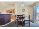 Bright dining nook featuring a wooden table, seating for four, and modern lighting fixture and adjacent to the kitchen at 6048 Pele St, North Las Vegas, NV 89031