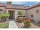 Close-up view of the home's entry with landscaped garden featuring red roses and palm tree at 6048 Pele St, North Las Vegas, NV 89031