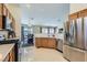 Modern kitchen with stainless steel appliances, wooden cabinets, and tiled flooring, ideal for cooking at 6048 Pele St, North Las Vegas, NV 89031