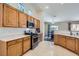 Bright kitchen with wooden cabinetry, stainless steel appliances, and tile flooring at 6048 Pele St, North Las Vegas, NV 89031
