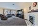Spacious living room with carpeted flooring, a fireplace, and large windows for plenty of sunlight at 6048 Pele St, North Las Vegas, NV 89031