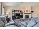 Comfortable living room featuring plush sofas, a fireplace, and ample natural light from large windows at 6048 Pele St, North Las Vegas, NV 89031