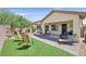 Spacious backyard with lush artificial turf, a brick patio, and a variety of outdoor seating options at 6072 Canter Glen Ave, Las Vegas, NV 89122