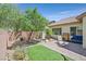 Landscaped backyard with lush greenery, a patio area, and outdoor seating at 6072 Canter Glen Ave, Las Vegas, NV 89122