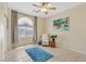 Comfortable bedroom with tile flooring, a ceiling fan, and a relaxing chair at 6072 Canter Glen Ave, Las Vegas, NV 89122
