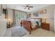 Comfortable bedroom with a king-size bed, ceiling fan, and large windows offering a serene view at 6072 Canter Glen Ave, Las Vegas, NV 89122