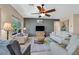 Bright living room featuring neutral tones, comfortable seating, and a modern ceiling fan at 6072 Canter Glen Ave, Las Vegas, NV 89122