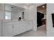 Bright bathroom with dual sinks, white cabinets, and a glimpse into a spacious walk-in closet at 6148 Juniper Grove St, Las Vegas, NV 89148