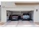 Two-car garage with brick flooring, two vehicles, and utility connections on the wall at 6148 Juniper Grove St, Las Vegas, NV 89148