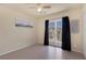 A bedroom with wood-like floors, fan, and sliding doors to the balcony at 6217 Lapilli Ave, Las Vegas, NV 89139