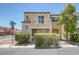 Two-story tan home featuring a balcony, manicured bushes, and a two-car garage at 6217 Lapilli Ave, Las Vegas, NV 89139