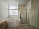 Bathroom featuring a soaking tub, glass block window, and separate shower at 6435 Heatherton Ave, Las Vegas, NV 89110