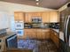Kitchen featuring wooden cabinetry, stainless steel appliances, and tile flooring at 6435 Heatherton Ave, Las Vegas, NV 89110