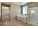 Bright bathroom with a soaking tub, a glass enclosed shower, and tiled floors at 6442 American Eagle Ave, Las Vegas, NV 89131