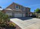 Two-story home with a three-car garage, desert landscaping, and a sunny sky at 669 Kentons Run Ave, Henderson, NV 89052