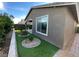 Landscaped backyard with artificial turf and tidy gravel and shrubbery ground cover at 6756 Millbury St, North Las Vegas, NV 89086