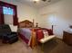 Cozy bedroom with a wooden bed frame, dark red accents, and neutral-toned walls at 6756 Millbury St, North Las Vegas, NV 89086
