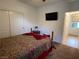 Bedroom with patterned bedding, a mounted TV, and ensuite bathroom access at 6756 Millbury St, North Las Vegas, NV 89086