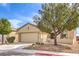 Charming home with a two-car garage, desert landscaping, and a tree in the front yard at 7824 Homing Pigeon St, North Las Vegas, NV 89084
